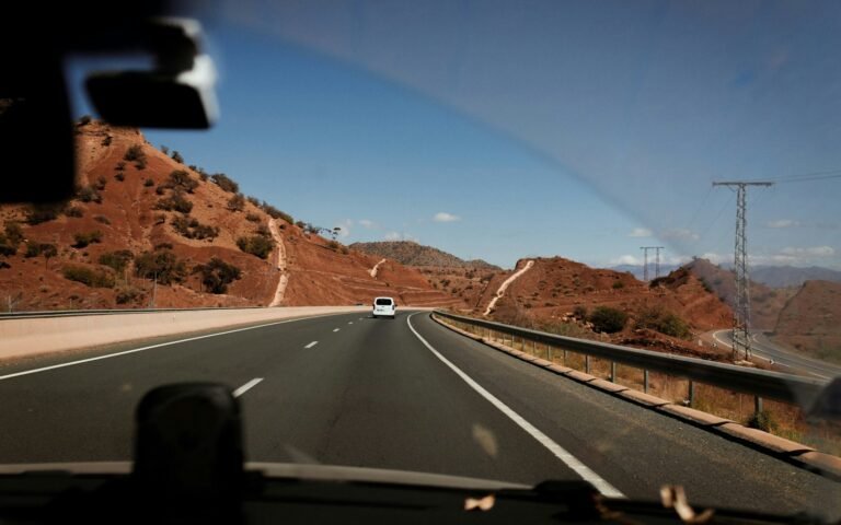 Road through red mountains seen from a car in Morocco