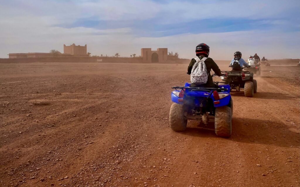 Quad bikes riding through the desert near a kasbah in Morocco